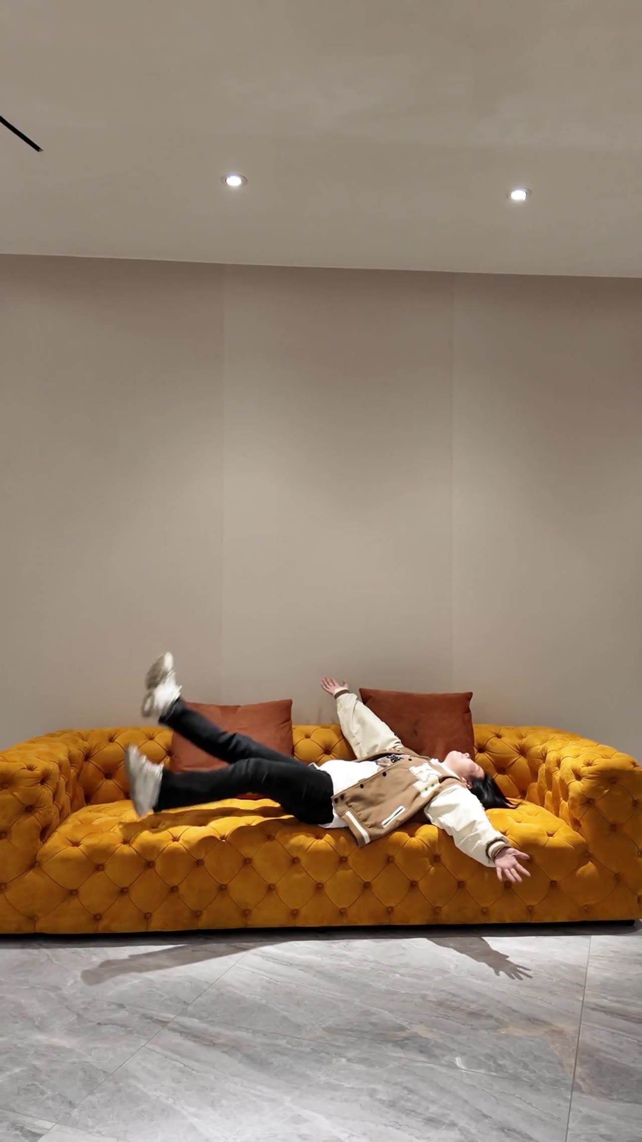 Person relaxing on stylish tufted sofa in showroom