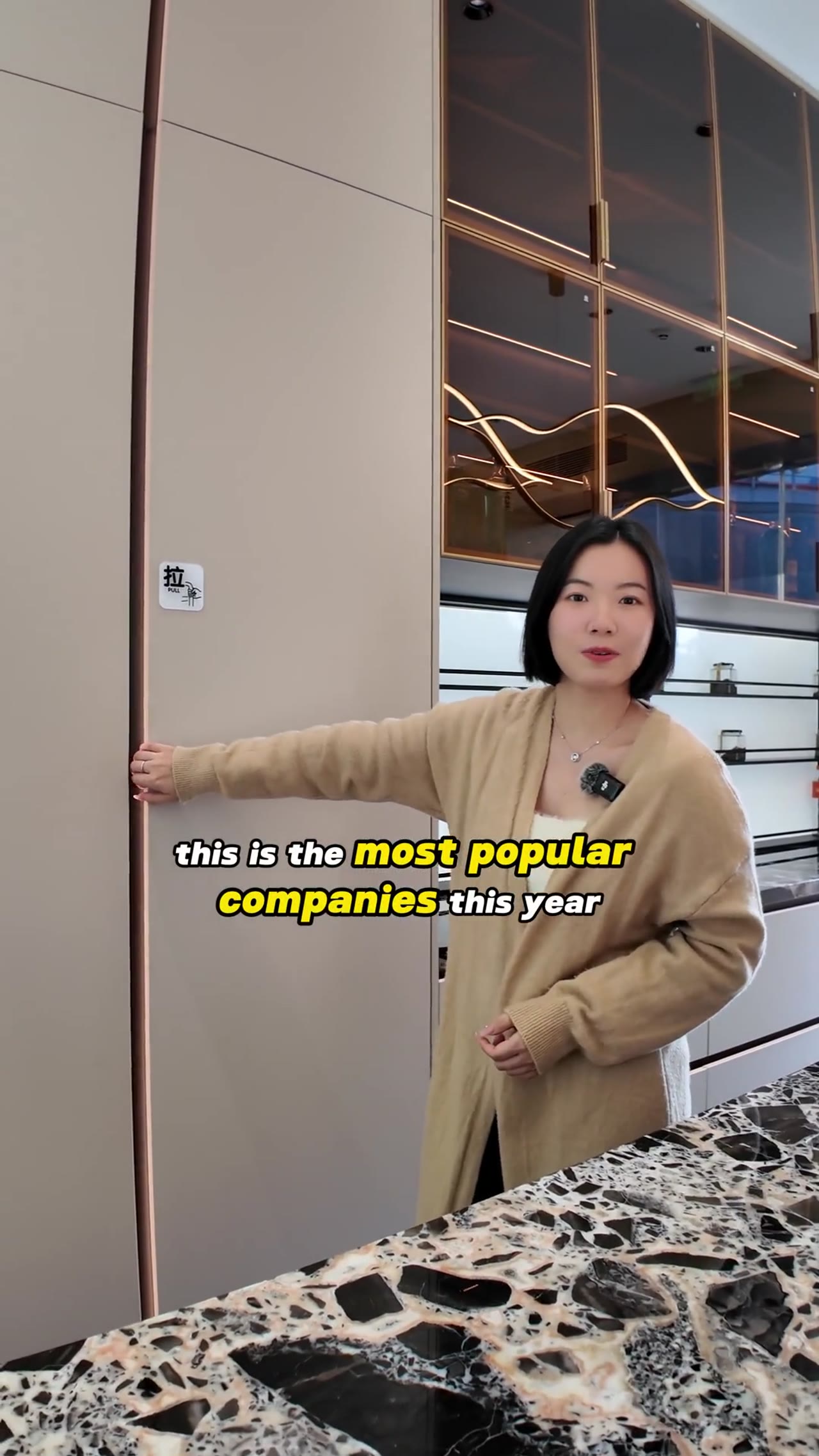 Woman presenting modern kitchen cabinets in showroom
