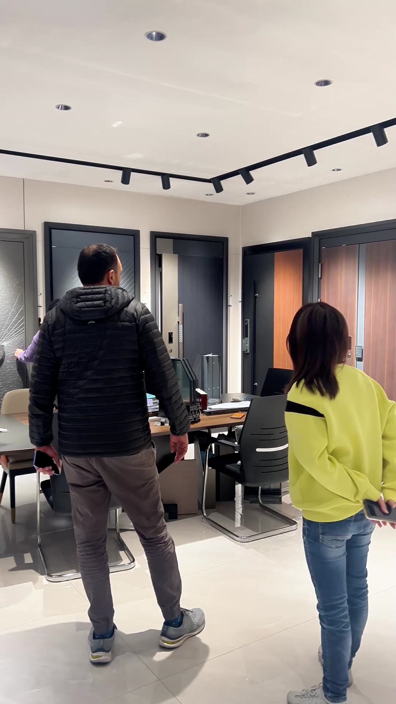 Presenter showcases modern kitchen cabinet in showroom